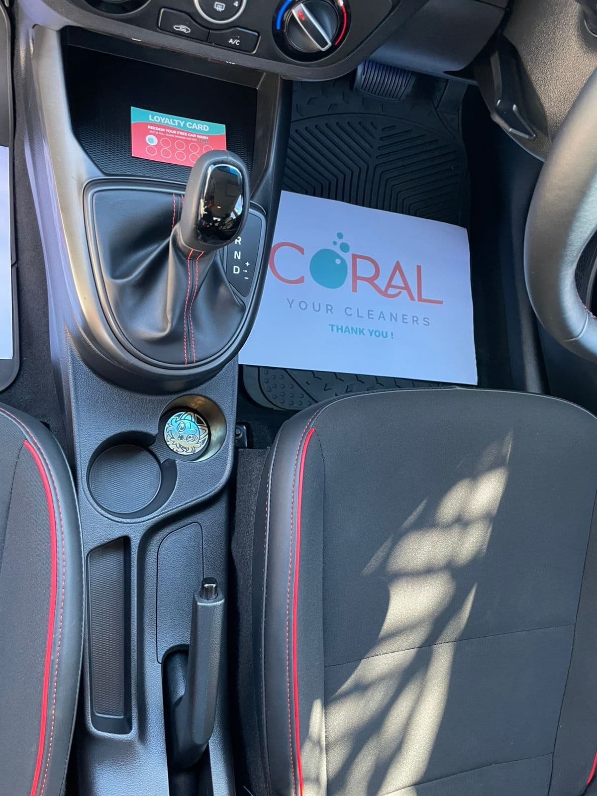 Detailed centre console with a Coral Cleaners thank-you sheet and loyalty card